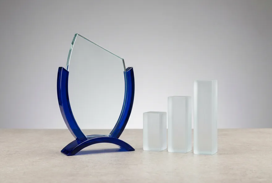 Glas-Award mit blauem Sockel neben aufsteigenden Balken